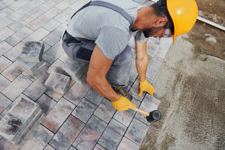construction-worker-laying-stone-pavers-on-ground-2026-03-24-06-14-48-utc